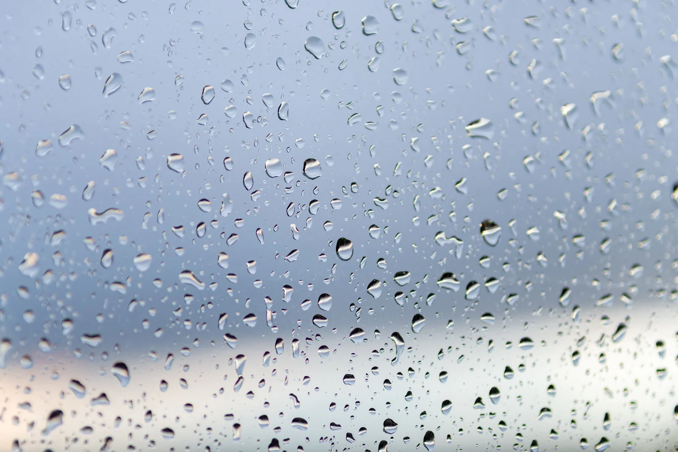 Condensation beaded on a living room window pane on a humid day