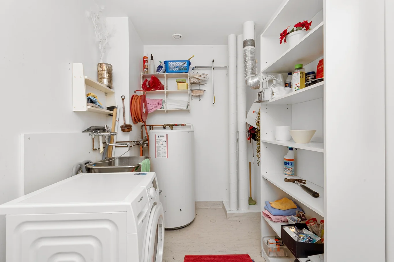 Basement utility room with a washing machine and water heater