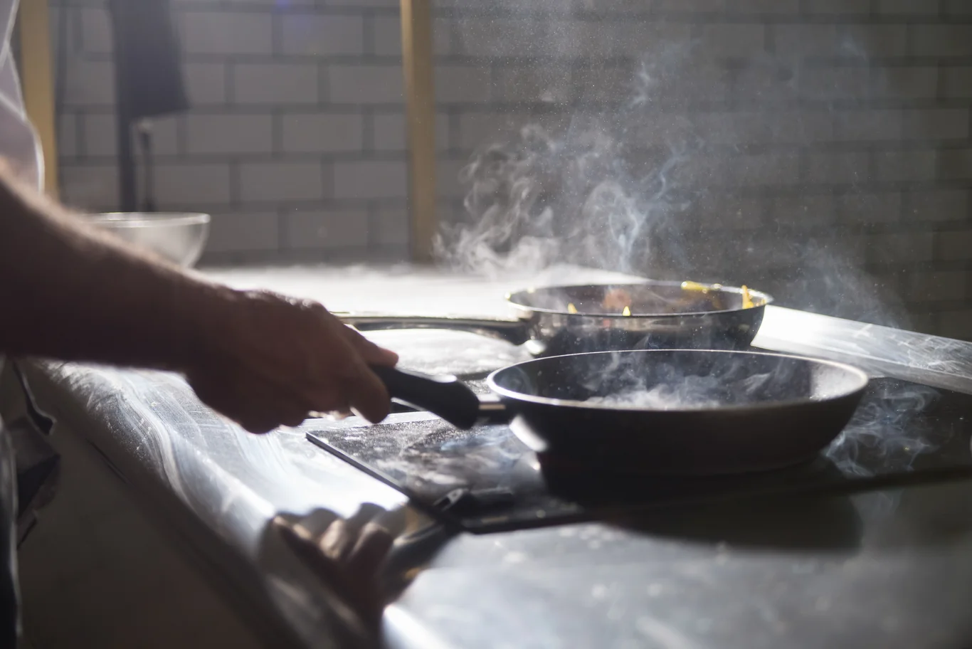 Smoke rising from a pan while cooking on a home kitchen stove
