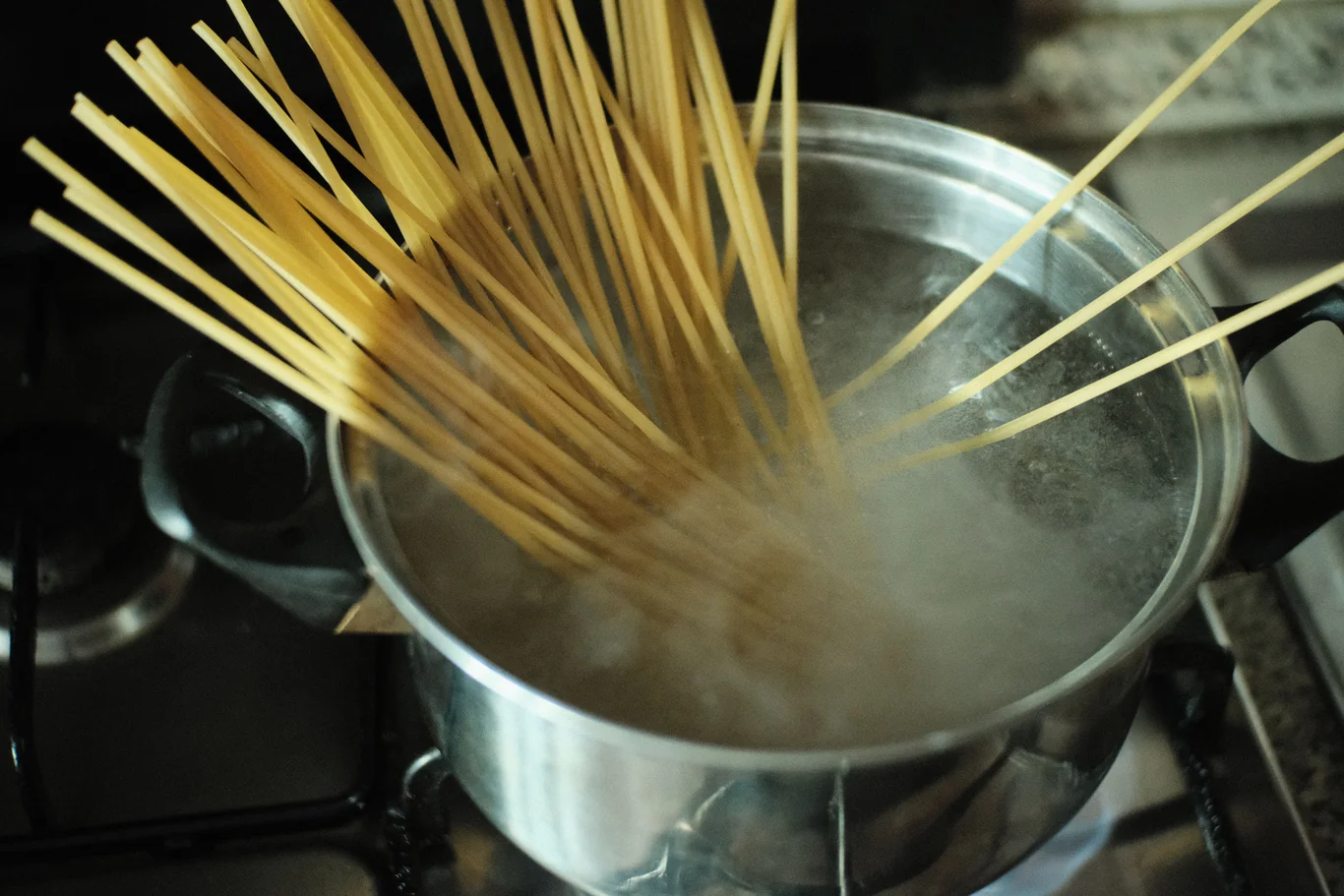 Steam rising from a pot of boiling pasta on a stovetop