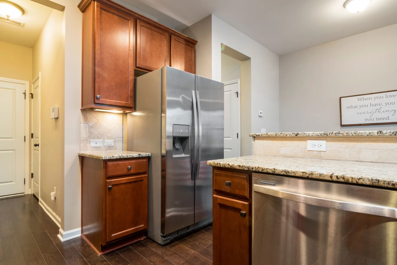Stainless steel refrigerator with a water and ice dispenser in a kitchen