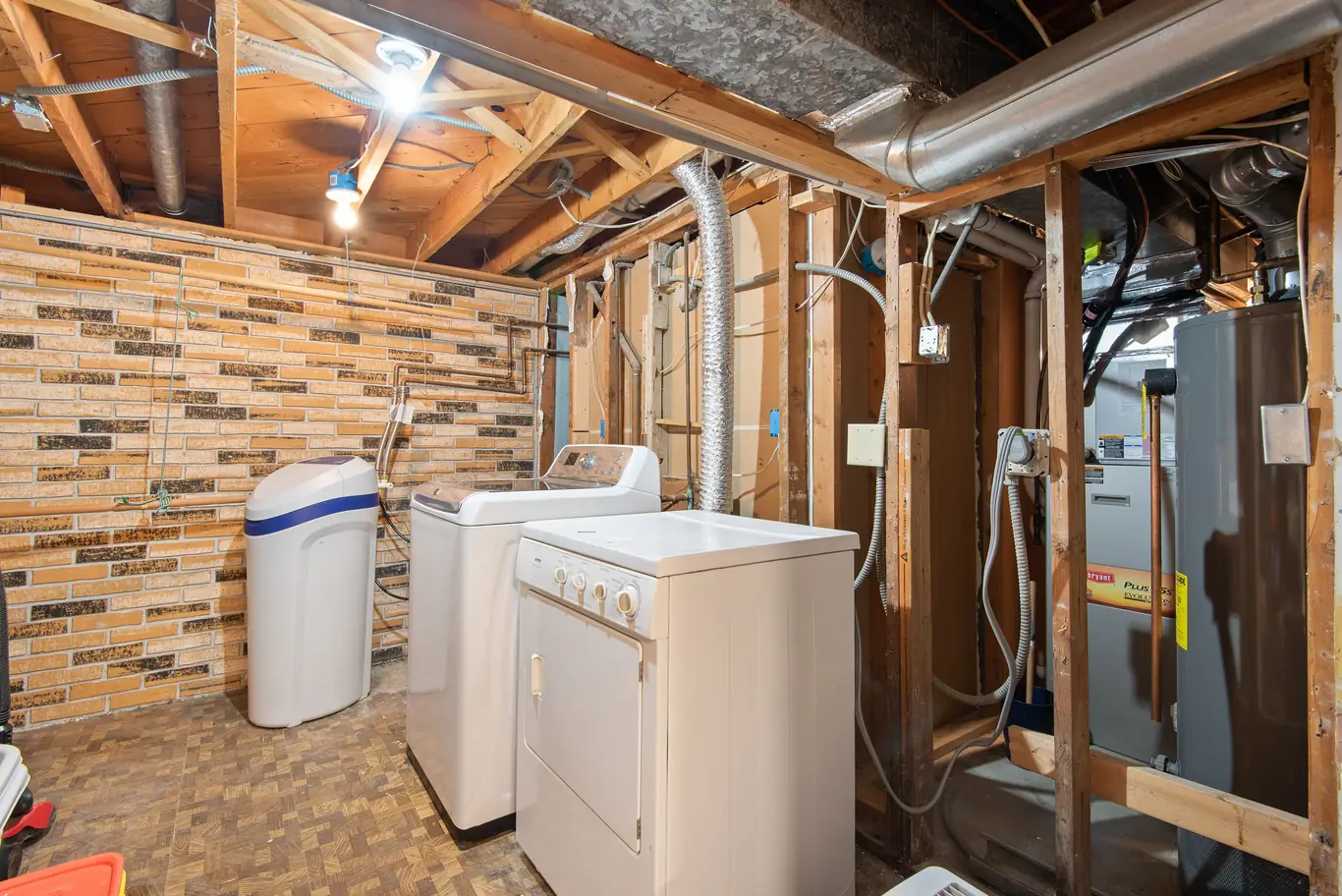 Water treatment tank standing in an unfinished basement utility area