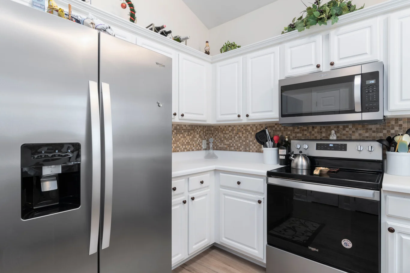 Stainless steel side-by-side refrigerator with a door dispenser in a kitchen