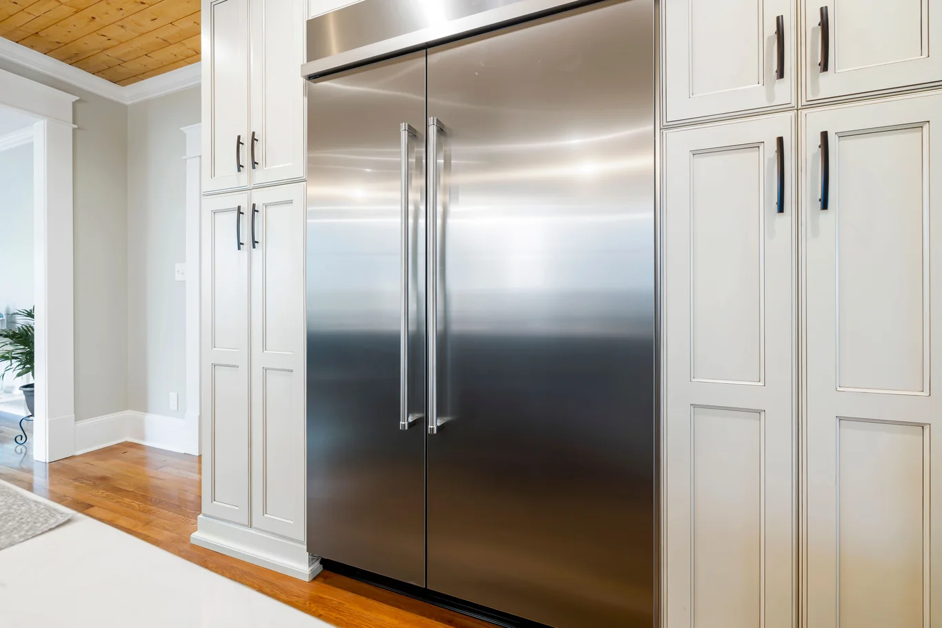 Stainless steel refrigerator in a kitchen showing the lower grille panel