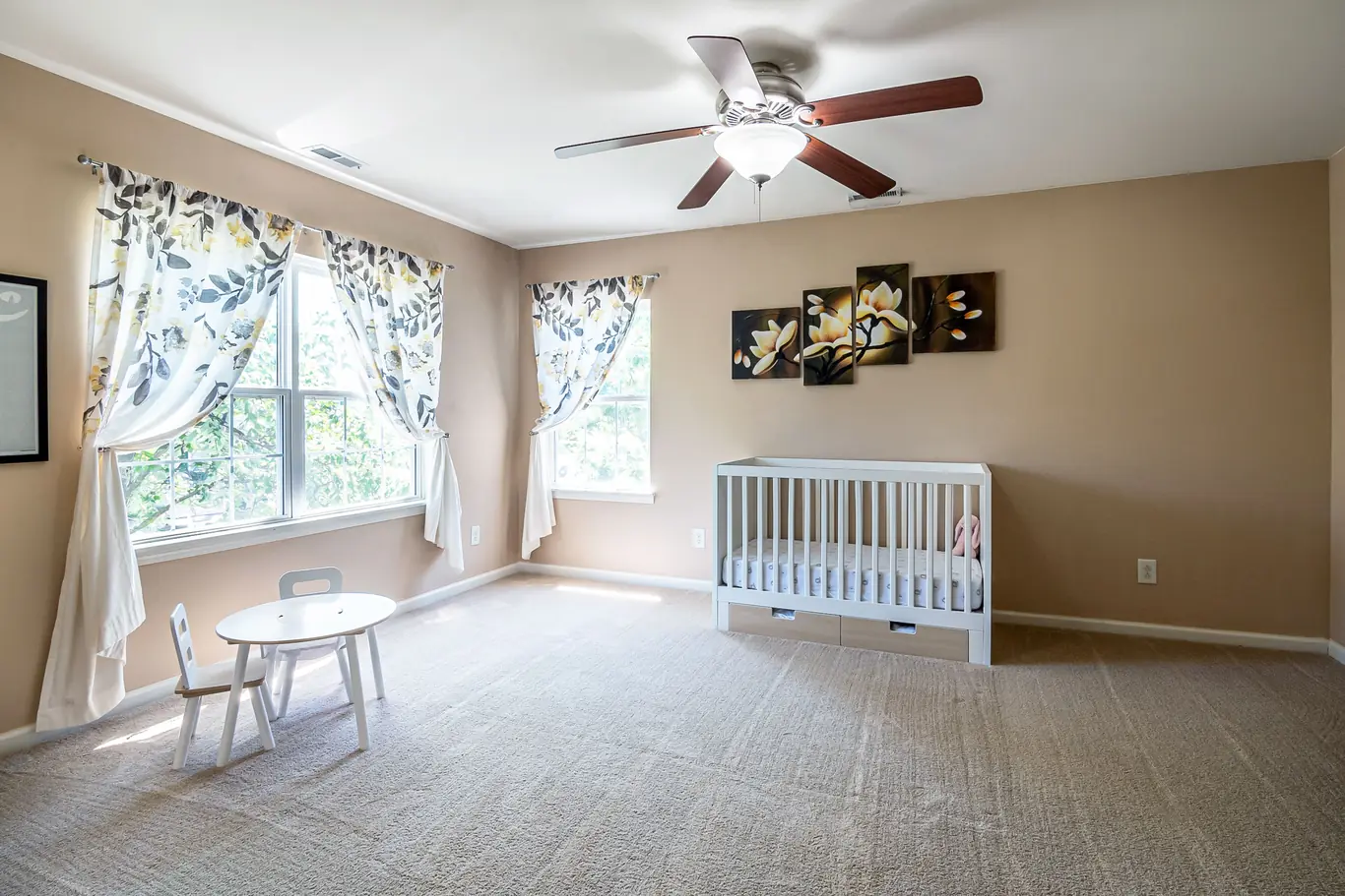 Spacious nursery room with a white crib and plenty of open floor space